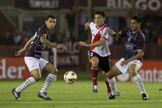 River Plate's Matias Kranevitter, center, vies for the ball with Diego Gonzalez, right, and Maximiliano Velazquez, left, of Argentina's Lanus during a Copa Sudamericana soccer match on Tuesday, Oct. 29, 2013, in Buenos Aires, Argentina. (AP Photo/Eduardo Di Baia)