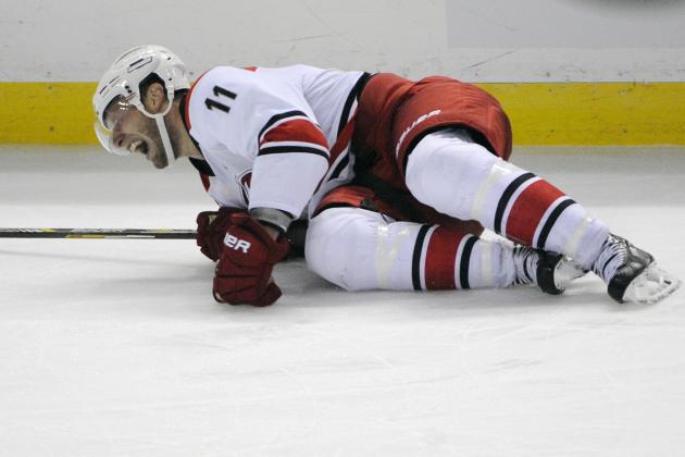 Carolina Hurricanes center Jordan Staal grimaces as he lays on the ice during the third period action of an NHL hockey preseason game against the Buffalo Sabres, Tuesday, Sept. 23, 2014, in Buffalo, N.Y. (AP Photo/Gary Wiepert)