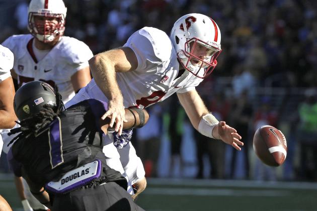 Stanford quarterback Kevin Hogan, right, fumbles the ball after being hit by Washington's Shaq Thompson (7) in the second half of an NCAA football game Saturday, Sept. 27, 2014, in Seattle. Stanford won 20-13.(AP Photo/Elaine Thompson)