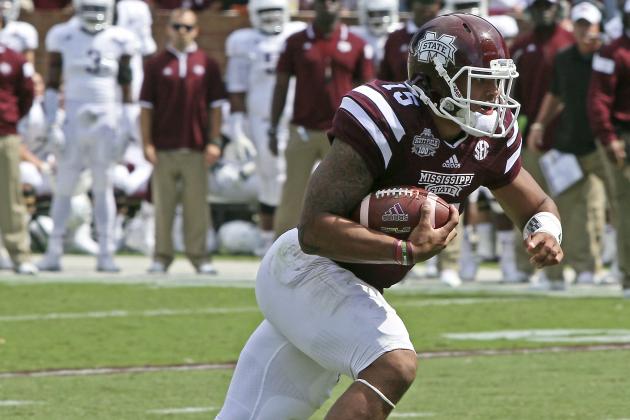 Mississippi State quarterback Dak Prescott (15) gains additional yardage after receiving a pass during the first half of an NCAA college football game against Texas A&M in Starkville, Miss., Saturday, Oct. 4, 2014. (AP Photo/Jim Lytle)