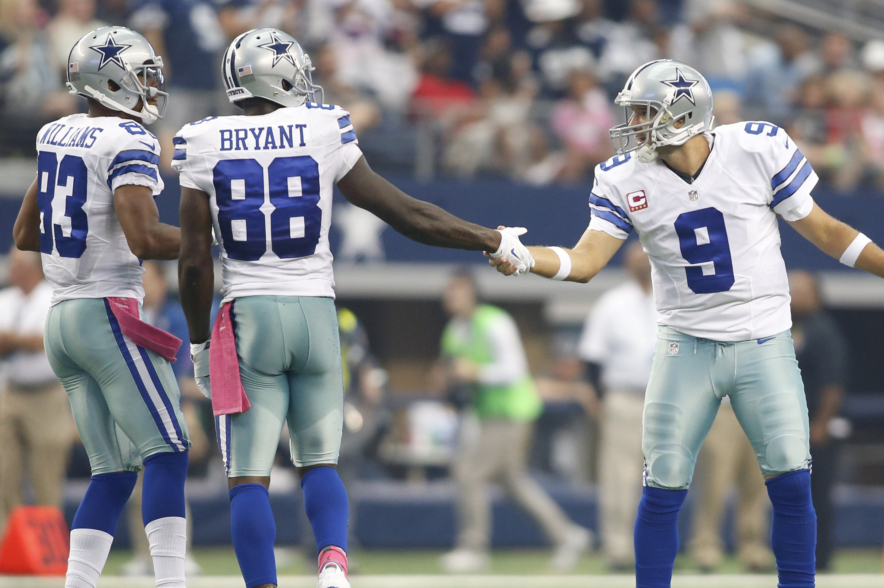 Tony Romo of the Dallas Cowboys holds the ball under pressure from