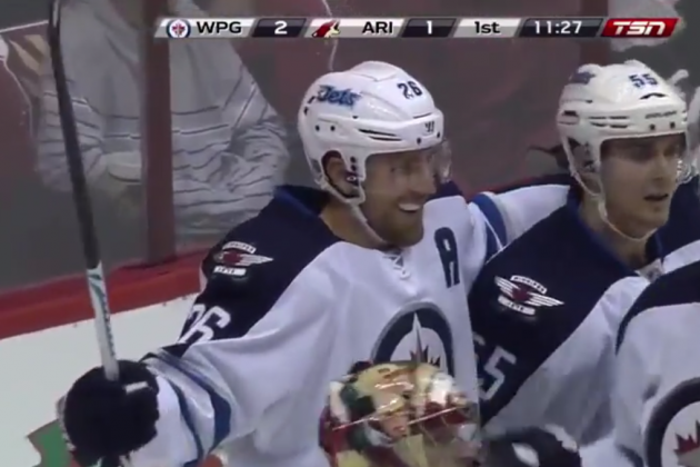 Winnipeg Jets' Blake Wheeler (26) celebrates his goal, the first of two during the first period, against the Arizona Coyotes as Coyotes' Oliver Ekman-Larsson (23), of Sweden, skates in front of the goal area in an NHL hockey game Thursday, Oct. 9, 2014, in Glendale, Ariz. (AP Photo/Ross D. Franklin)
