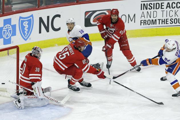 New York Islanders' Mikhail Grabovski (84), of Germany, shoots and scores on Carolina Hurricanes goalie Cam Ward (30) as Hurricanes' Ron Hainsey (65) and Jay Harrison (44) defend during the third period of an NHL hockey game in Raleigh, N.C., Friday, Oct. 10, 2014. New York won 5-3. Islanders' Ryan Strome (18) looks on at rear. (AP Photo/Gerry Broome)