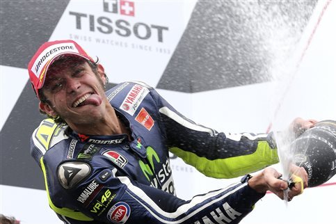 In this photo taken on Sunday, Oct. 19, 2014, MotoGP rider Valentino Rossi of Italy sprays champagne as he celebrates after winning the Australian Motorcycle Grand Prix at Phillip Island, Australia.  (AP Photo/Rob Griffith)