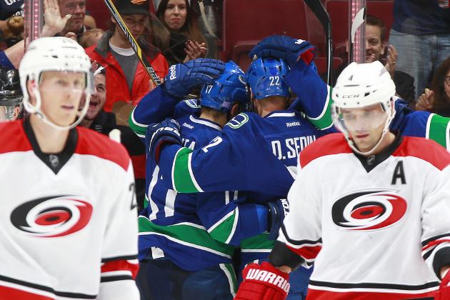 VANCOUVER, BC - OCTOBER 28:  Daniel Sedin #22 and the Vancouver Canucks celebrate a goal behind Riley Nash #20 and Andrej Sekera #4 of the Carolina Hurricanes during their NHL game at Rogers Arena October 28, 2014 in Vancouver, British Columbia, Canada.  (Photo by Jeff Vinnick/NHLI via Getty Images)