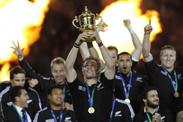 New Zealand All Blacks captain Richie McCaw holds up the Webb Ellis trophy as teammates celebrate after their Rugby World Cup final win over France in Auckland, New Zealand, Sunday, Oct. 23, 2011. (AP Photo/Christophe Ena)