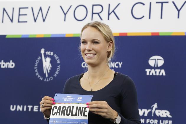 Professional tennis player Caroline Wozniacki poses with her runner's bib during a news conference, Wednesday, Oct. 29, 2014, in New York. The Danish tennis star, formerly top-ranked in the world,  will run the New York City Marathon, Sunday, Nov. 2, to raise funds for the New York Road Runners Team for Kids charity, which promotes youth running. (AP Photo/Mark Lennihan)