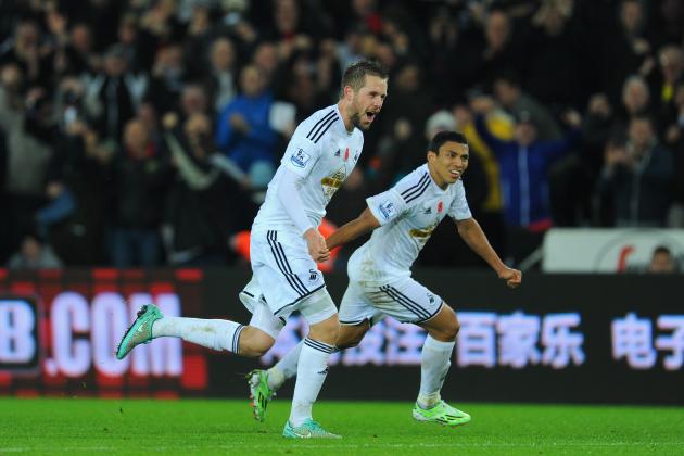 SWANSEA, WALES - NOVEMBER 09:  Swansea players Gylfi Sigurdsson (l) and Jefferson Montero celebrate the first Swansea goal during the Barclays Premier League match between Swansea City and Arsenal at Liberty Stadium on November 9, 2014 in Swansea, Wales.  (Photo by Stu Forster/Getty Images)