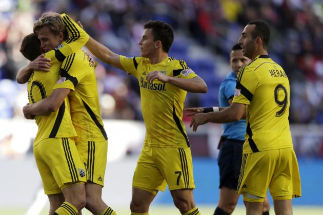 Columbus Crew's Aaron Schoenfeld, second from left, is hugged by Wil Trapp, left, as teammates Bernardo Anor, second from front right, and Justin Meram, right, celebrate a goal by Schoenfeld against the New York Red Bulls during the first half of an MLS soccer match, Sunday, Oct. 19, 2014, in Harrison, N.J. (AP Photo/Julio Cortez)