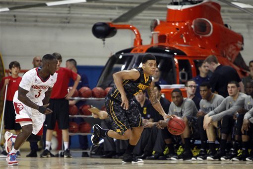 Minnesota’s Nate Mason, right, dribbles the ball as Louisville’s Chris Jones follows during a NCAA college basketball Armed Forces Classic game inside a hangar at the United States Coast Guard Air Station base in Aguadilla, Puerto Rico, Friday, Nov. 14, 2014. (AP Photo/Ricardo Arduengo)