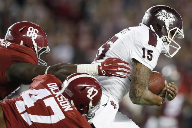 Mississippi State quarterback Dak Prescott (15) is taken down by Alabama linebacker Xzavier Dickson (47) and Alabama defensive lineman A'Shawn Robinson (86) during the second half of an NCAA college football game Saturday, Nov. 15, 2014, in Tuscaloosa, Ala. Alabama won 25-20. (AP Photo/Brynn Anderson)