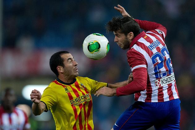 MADRID, SPAIN - DECEMBER 18: Emiliano Insua (R) of Atletico de Madrid competes for the ball with Xapi Arnau (L) of UE Sant Andreu during the Copa del Rey Round of 32 second leg match between Club Atletico de Madrid and Sant Andreu at Vivente Calderon Stadium on December 18, 2013 in Madrid, Spain. (Photo by Gonzalo Arroyo Moreno/Getty Images)
