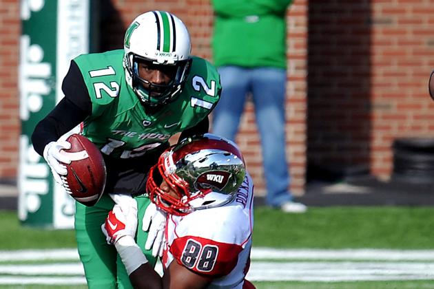 Marshall's Rakeem Cato (12) is taken down by Western Kentucky's Gavin Rocker during an NCAA football game in  Huntington, W.Va., Friday, Nov. 28, 2014. (AP Photo/Chris Tilley)