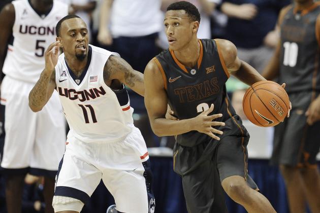 Texas’ Demarcus Holland, right, dribbles as Connecticut’s Ryan Boatright, left, defends during the second half of an NCAA college basketball game, Sunday, Nov. 30, 2014, in Storrs, Conn. Texas won 55-54. (AP Photo/Jessica Hill)