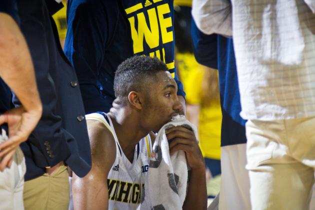 Michigan guard Zak Irvin (21) sits in a huddle with teammates during a timeout in the second half of an NCAA college basketball game against N.J.I.T. at Crisler Center in Ann Arbor, Mich., Saturday, Dec. 6, 2014. N.J.I.T. won 72-70. (AP Photo/Tony Ding)