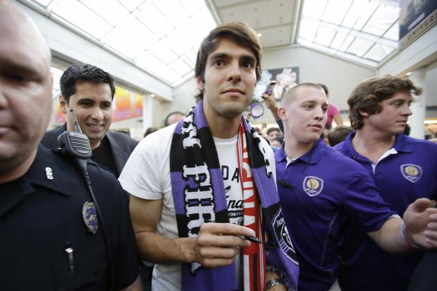 Brazilian soccer star Kaka, center, surrounded by security and police officers, makes his way through a crowd of fans at Orlando International Airport, Monday, June 30, 2014, in Orlando, Fla. Kaka is the first designated player to sign with the Orlando City Soccer Club and the team will begin play in Major League Soccer in 2015. (AP Photo/John Raoux)