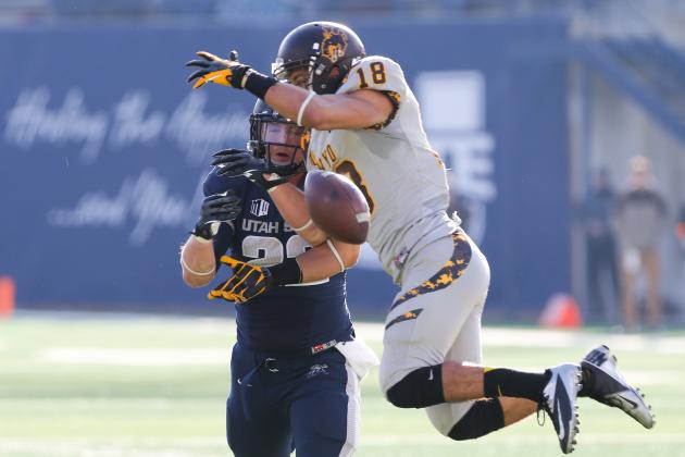 Nov 30, 2013; Logan, UT, USA; Utah State Aggies tight end Keegan Andersen (22) and Wyoming Cowboys safety Xavier Lewis (18) both attempt to catch the ball during the third quarter at Romney Stadium. Utah State Aggies won the game 35-7. Mandatory Credit: Chris Nicoll-USA TODAY Sports