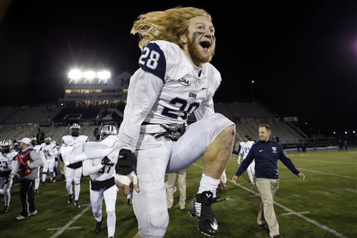 New Hampshire defensive back Casey DeAndrade (28) leaps for joy after the Wildcats defeated Maine 20-12 in an NCAA college football game, Saturday, Nov. 22, 2014, at Alfond Stadium in Orono, Maine. (AP Photo/Robert F. Bukaty)
