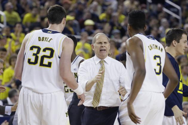 Michigan head coach John Beilein  talks to forward Ricky Doyle (32) and guard Kameron Chatman (3) during the first half of an NCAA college basketball game against Illinois in Ann Arbor, Mich., Tuesday, Dec. 30, 2014. (AP Photo/Carlos Osorio)
