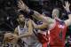 San Antonio Spurs' Tim Duncan, left, is pressured by Washington Wizards' Paul Pierce, center, and Marcin Gortat (4) during the second half of an NBA basketball game, Saturday, Jan. 3, 2015, in San Antonio. (AP Photo/Eric Gay)