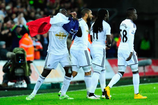 SWANSEA, WALES - JANUARY 10:  Bafetimbi Gomis of Swansea (l) celebrates with team mates and the France national flag after scoring during  the Barclays Premier League match between Swansea City and West Ham United at Liberty Stadium on January 10, 2015 in Swansea, Wales.  (Photo by Stu Forster/Getty Images)