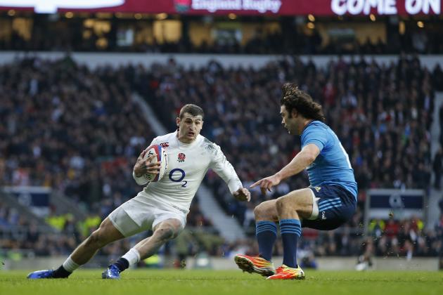 England’s England’s Jonny May, left, slips as he takes on Italy’s Luke McLean during the Six Nations international rugby union match against Italy at Twickenham stadium in London, Saturday, Feb. 14, 2015. (AP Photo/Alastair Grant)