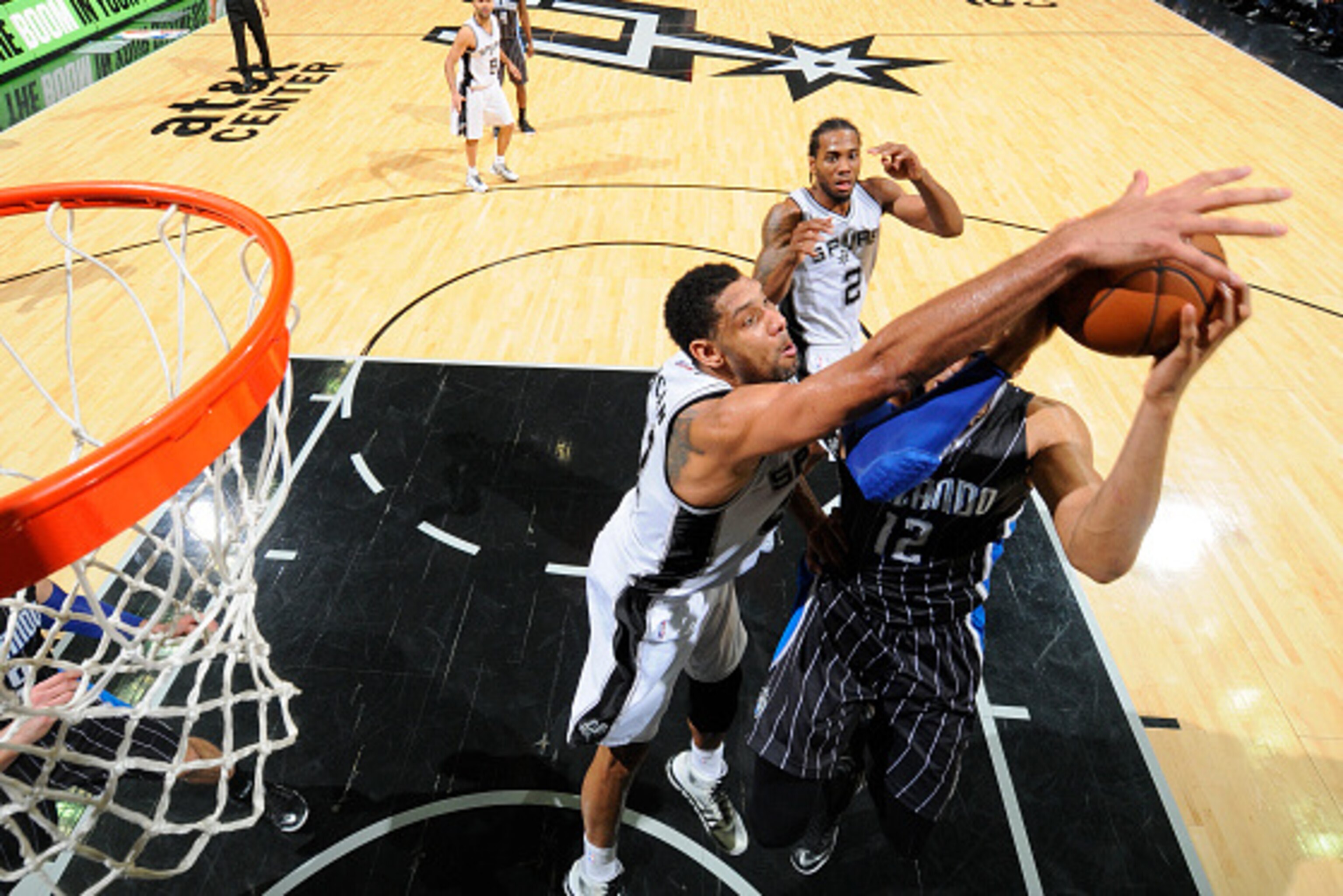 Tim Duncan défendant sur Dwight Howard, avec Kawhi Leonard qui l'observe