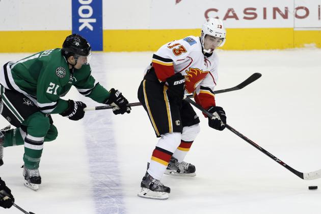 Dallas Stars left wing Antoine Roussel (21) of France pressures as Calgary Flames' Johnny Gaudreau (13) controls the puck in the second period of an NHL hockey game Monday, March 30, 2015, in Dallas. (AP Photo/Tony Gutierrez)
