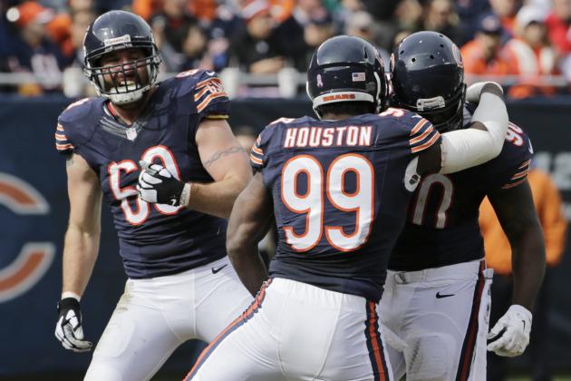 Chicago Bears defensive tackle Jeremiah Ratliff, right, celebrates a quarterback sack against the Miami Dolphins with defensive ends Lamarr Houston (99) and Jared Allen (69) during the first half of an NFL football game Sunday, Oct. 19, 2014 in Chicago. (AP Photo/Charles Rex Arbogast)