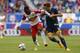 Apr 26, 2015; Harrison, NJ, USA; New York Red Bulls midfielder Lloyd Sam (10) controls the ball against Los Angeles Galaxy midfielder Robbie Rogers (14) during second half at Red Bull Arena. Final score 1-1. Mandatory Credit: Noah K. Murray-USA TODAY Sports
