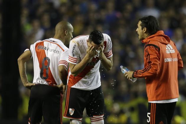 Ramiro Funes Mori of Argentina's River Plate, center, and teammates wash their faces after a caustic substance was thrown at them from the stands, at the start of the second half of a Copa Libertadores round of sixteen soccer match against Boca Juniors in Buenos Aires, Argentina, Thursday, May 14, 2015. (AP Photo/Victor R. Caivano)