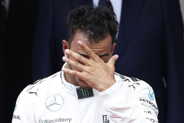 Third placed Mercedes driver Lewis Hamilton of Britain touches his face on the podium after the Formula One Grand Prix, at the Monaco racetrack, in Monaco, Sunday, May 24, 2015. (AP Photo/Luca Bruno)
