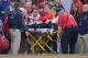 A fan, who was accidentally hit in the head with a broken bat by Boston Red Sox's Xander Bogaerts, is helped from the stands during a baseball game against the Oakland Athletics at Fenway Park in Boston, Friday, June 5, 2015. The game stopped and the woman was wheeled down to the first base line to be transported to a local hospital. (AP Photo/Charles Krupa)