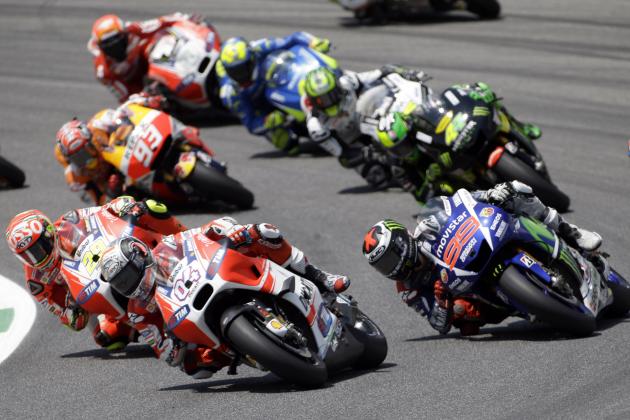 Jorge Lorenzo, right, steers his Yamaha past Ducati's rider Andrea Dovizioso, center, and Ducati's rider Andrea Iannone, left, during the Italian MotoGP, at the Mugello race circuit, in Scarperia, Italy, Sunday, May 31, 2015. Jorge Lorenzo won the race ahead of Italy's Andrea Iannone and Italy's Valentino Rossi. (AP Photo/Gregorio Borgia)