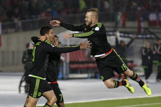 Mexico's Raul Jimenez, left, celebrates after scoring his side's second goal against Chile, with teammates Jesus Corona, center, and Matias Vuoso during a Copa America Group A soccer match at El Nacional stadium in Santiago, Chile, Monday, June 15, 2015. (AP Photo/Natacha Pisarenko)