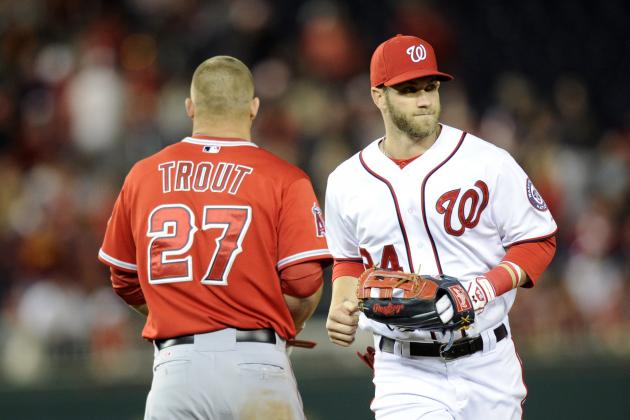 Washington Nationals left fielder Bryce Harper (34) runs from the field past Los Angeles Angels' Mike Trout (27) during the middle of the seventh inning of a baseball game, Monday, April 21, 2014, in Washington. The Angels won 4-2. (AP Photo/Nick Wass)