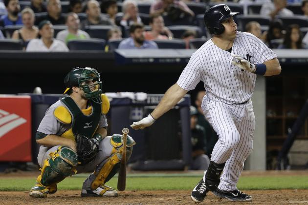 New York Yankees' Mark Teixeira, right, follows through on a solo home run as Oakland Athletics catcher Josh Phegley watches during the sixth inning of a baseball game, Wednesday, July 8, 2015, in New York. (AP Photo/Julie Jacobson)
