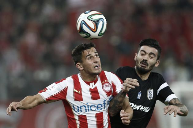 Olympiakos’ Ibrahim Afellay, challenges for a header with PAOK's Stefanos Athanasiadis right,  during a Greek super league soccer match at Georgios Karaiskakis Stadium in the port of Piraeus near Athens, Wednesday, Dec. 3, 2014. (AP Photo/Petros Giannakouris)