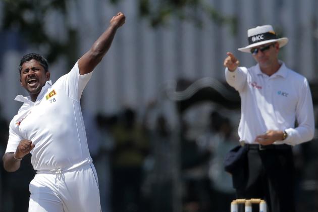 Sri Lanka's Rangana Herath, left, celebrates the dismissal of India's Ishant Sharma as the umpire signals his decision during the fourth day of their first test cricket match in Galle, Sri Lanka, Saturday, Aug. 15, 2015. (AP Photo/Eranga Jayawardena)