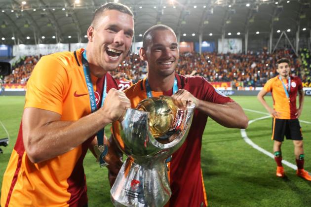 Galatasaray's Polish forward Lukas Podolski (L) and Dutch midfielder Wesley Sneijder celebrate with the trophy after winning the 2015 Turkish Super Cup final match against Bursaspor at Osmanli Stadium on August 08, 2015 in Ankara. Galatasaray defeated Bursaspor 1-0. AFP PHOTO / ADEM ALTAN (Photo credit should read ADEM ALTAN/AFP/Getty Images)