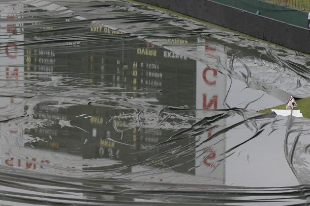 A member of the ground staff walks past the covered ground following a spell of rain during the day one of the third test cricket match between Sri Lanka and India, in Colombo, Sri Lanka, Friday, Aug. 28, 2015. (AP Photo/Eranga Jayawardena)