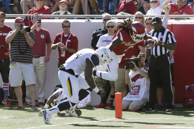 Arkansas running back Alex Collins (3) leaps into the end zone to score as he is tackled by Toledo linebacker Jaylen Coleman in first half of an NCAA college football game in Little Rock, Ark., Saturday, Sept. 12, 2015. (AP Photo/Danny Johnston)