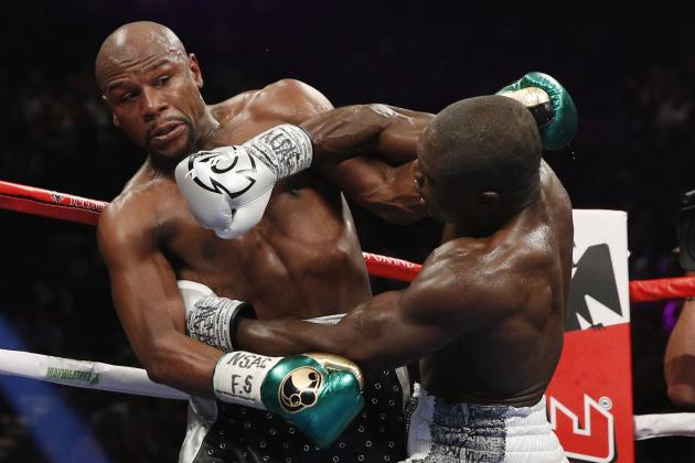Andre Berto, right, punches Floyd Mayweather Jr. during their welterweight title boxing bout Saturday, Sept. 12, 2015, in Las Vegas. (AP Photo/John Locher)
