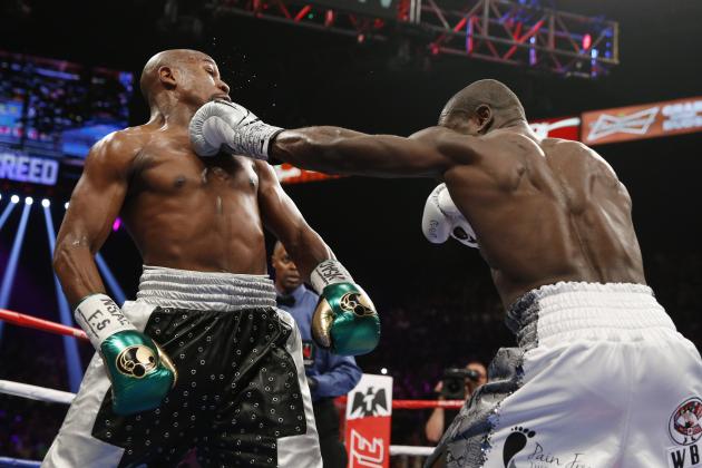 Andre Berto, right, hits Floyd Mayweather Jr. during their welterweight title boxing bout Saturday, Sept. 12, 2015, in Las Vegas. (AP Photo/John Locher)