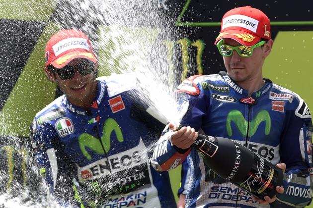 Movistar Yamaha MotoGP's Spanish rider Jorge Lorenzo (R) and Movistar Yamaha MotoGP's Italian rider Valentino Rossi (L) celebrate with champagne on the podium after the Catalunya Grand Prix at the Barcelona-Catalunya racetrack in Montmelo, near Barcelona on June 14, 2015.   AFP PHOTO / LLUIS GENE        (Photo credit should read LLUIS GENE/AFP/Getty Images)