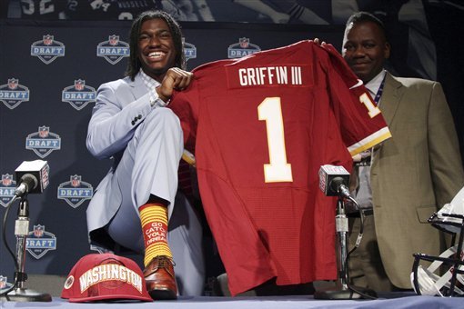 Baylor quarterback Robert Griffin III stands on the stage holding