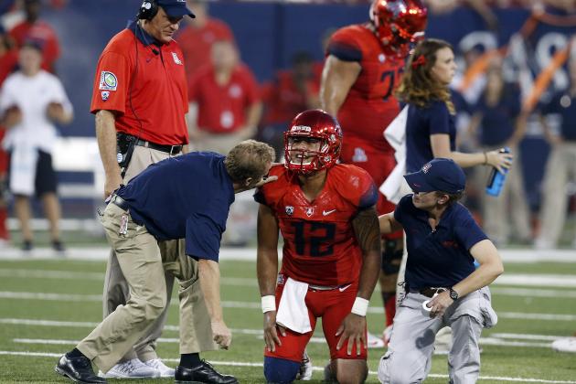 Arizona quarterback Anu Solomon (12) is checked by trainers during the first half of an NCAA college football game against UCLA, Saturday, Sept. 26, 2015, in Tucson, Ariz. (AP Photo/Rick Scuteri)