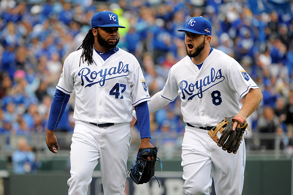 KANSAS CITY, MO - OCTOBER 09:  Mike Moustakas #8 of the Kansas City Royals reacts with Johnny Cueto #47 after closing the fourth inning against the Houston Astros during game two of the American League Division Series at Kauffman Stadium on October 9, 2015 in Kansas City, Missouri.  (Photo by Ed Zurga/Getty Images)