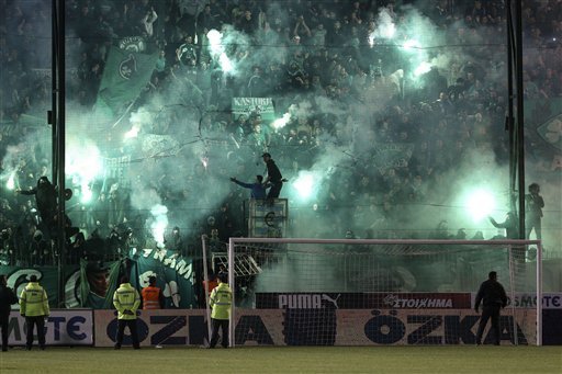 CORRECTS YEAR - Panathinaikos fans light flares after the cancellation of the Greek Super League match between Panathinaikos and Olympiakos at Apostolos Nikolaides stadium in Athens, Saturday, Nov. 21, 2015. The derby between host Panathinaikos and archrival Olympiakos, the Greek league’s frontrunner, has been cancelled after Panathinaikos fans clashed with police both outside and inside the football ground before the game and also threw flares at Olympiakos players when the latter entered the field. (AP Photo/Yorgos Karahalis)