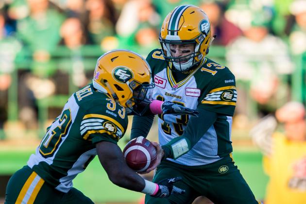 REGINA, SK - OCTOBER 24: Mike Reilly #13 hands the ball to Shakir Bell #33 of the Edmonton Eskimos in the game between the Edmonton Eskimos and Saskatchewan Roughriders in week 18 of the 2015 CFL season at Mosaic Stadium on October 24, 2015 in Regina, Saskatchewan, Canada.  (Photo by Brent Just/Getty Images)